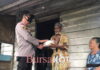 Ditengah Guyuran Hujan, Kapolres Natuna Berbagi Sembako di Teluk Buton