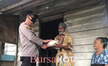 Ditengah Guyuran Hujan, Kapolres Natuna Berbagi Sembako di Teluk Buton
