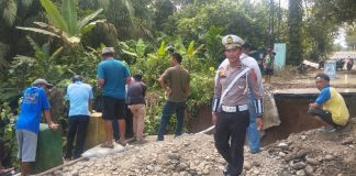 Unit Lantas Polsek Tanah Jawa Amankan Pengerjaan Jalan Rusak di Huta V Suhinagodang