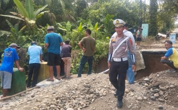 Unit Lantas Polsek Tanah Jawa Amankan Pengerjaan Jalan Rusak di Huta V Suhinagodang