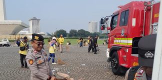 Personel Polri Sigap Bersih-bersih Kawasan Monas Usai May Day Fiesta