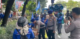 Polisi Bagikan 500 Duz Air Mineral Dan Permen Untuk Massa Buruh Di DPR