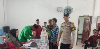 Brigadir Nofri, Bhabinkamtibmas Desa Teluk Kawal Distribusi Bantuan Pangan di Lingga Timur