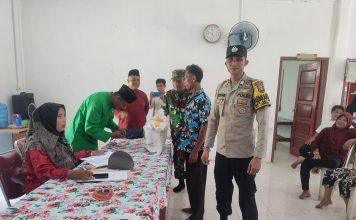 Brigadir Nofri, Bhabinkamtibmas Desa Teluk Kawal Distribusi Bantuan Pangan di Lingga Timur