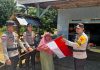 Satukan Semangat Kemerdekaan, Bhabinkamtibmas Polres Natuna Bagikan dan Ajak Warga Kibarkan Merah Putih